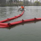 Barrage de confinement tracté par un petit bateau